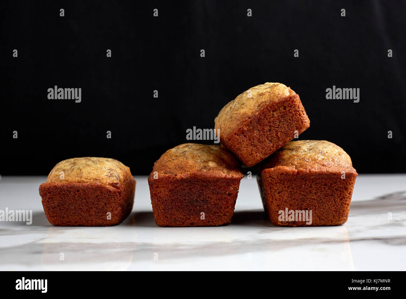 Mini focacce di pane alla banana su un marmo bianco tavolo e sfondo nero. Foto Stock