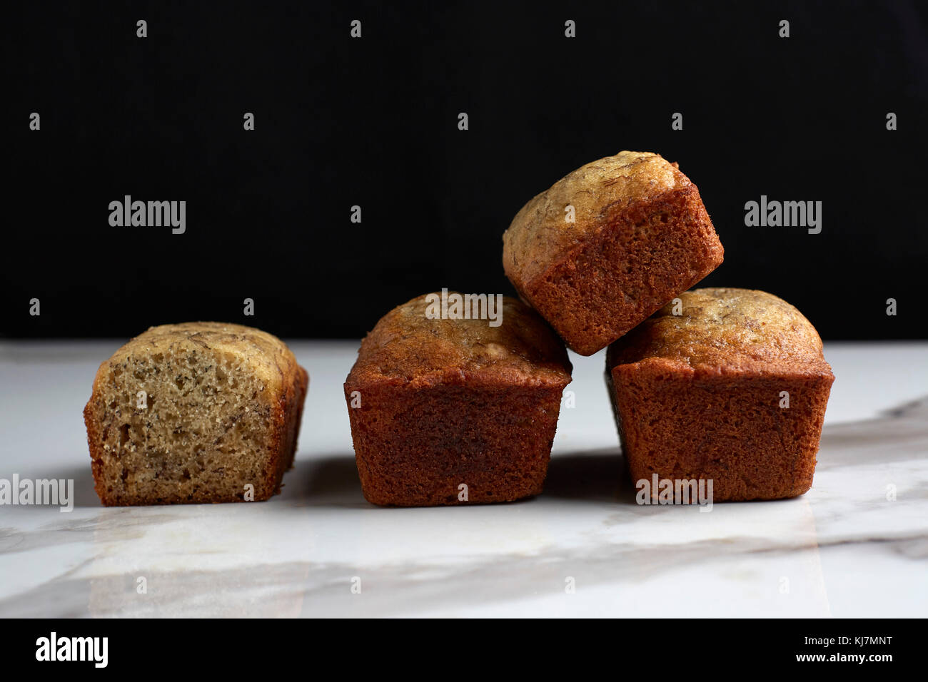 Mini focacce di pane alla banana su un marmo bianco tavolo e sfondo nero. Foto Stock