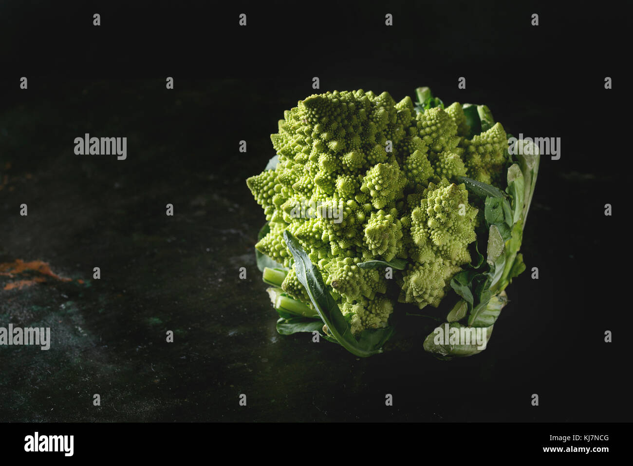 Freschi organici grezzi cavolo Broccolo romanesco su texture scuro dello sfondo. Mangiare sano concetto Foto Stock