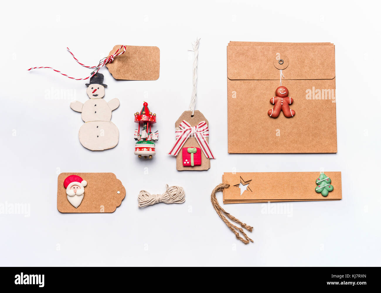 Regalo di natale il concetto di incarto. laici piana di vario artigianato carta eco confezione di cartone e i tag con l'annata pupazzo di neve e la decorazione sul desktop bianco b Foto Stock
