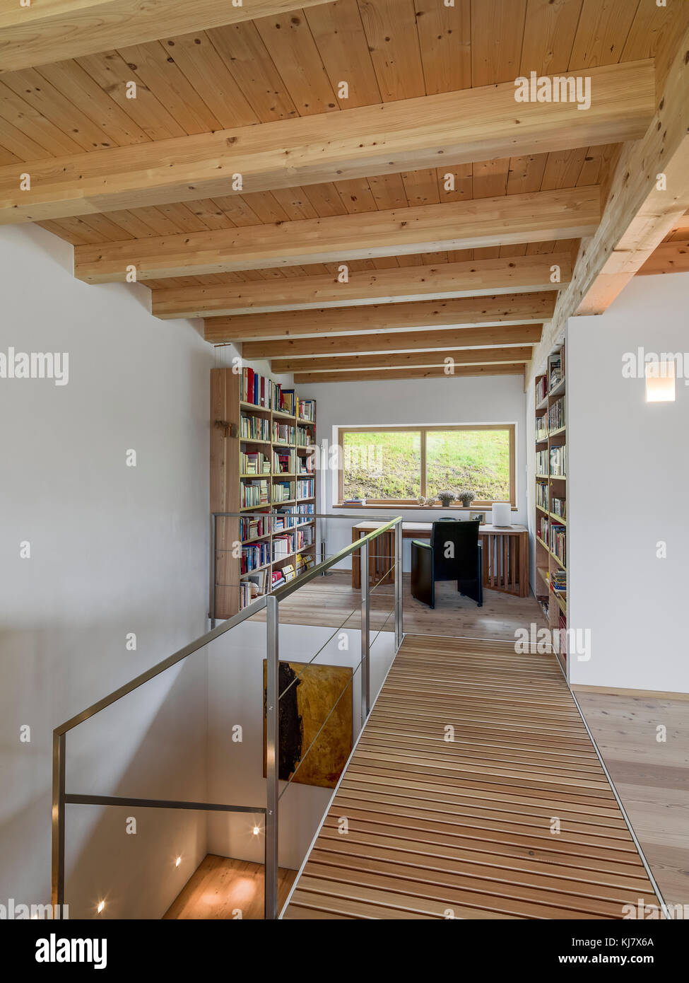 Scatti di interni di un moderno soggiorno con scrivania e la libreria con il pavimento e il soffitto sono realizzati in legno Foto Stock