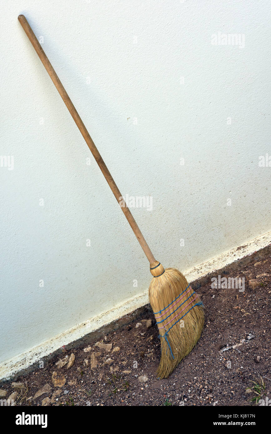 Una scopa o besom appoggiata contro un muro bianco con il pennello fine sul  pavimento Foto stock - Alamy