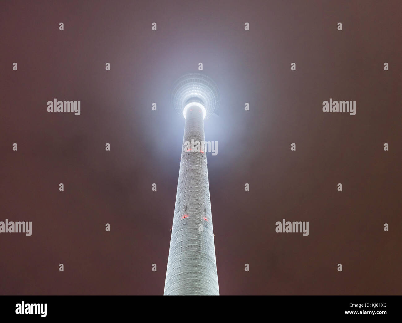 La torre della TV (Fernsehturm) avvolta in dense nubi di notte, Berlino, Germania Foto Stock