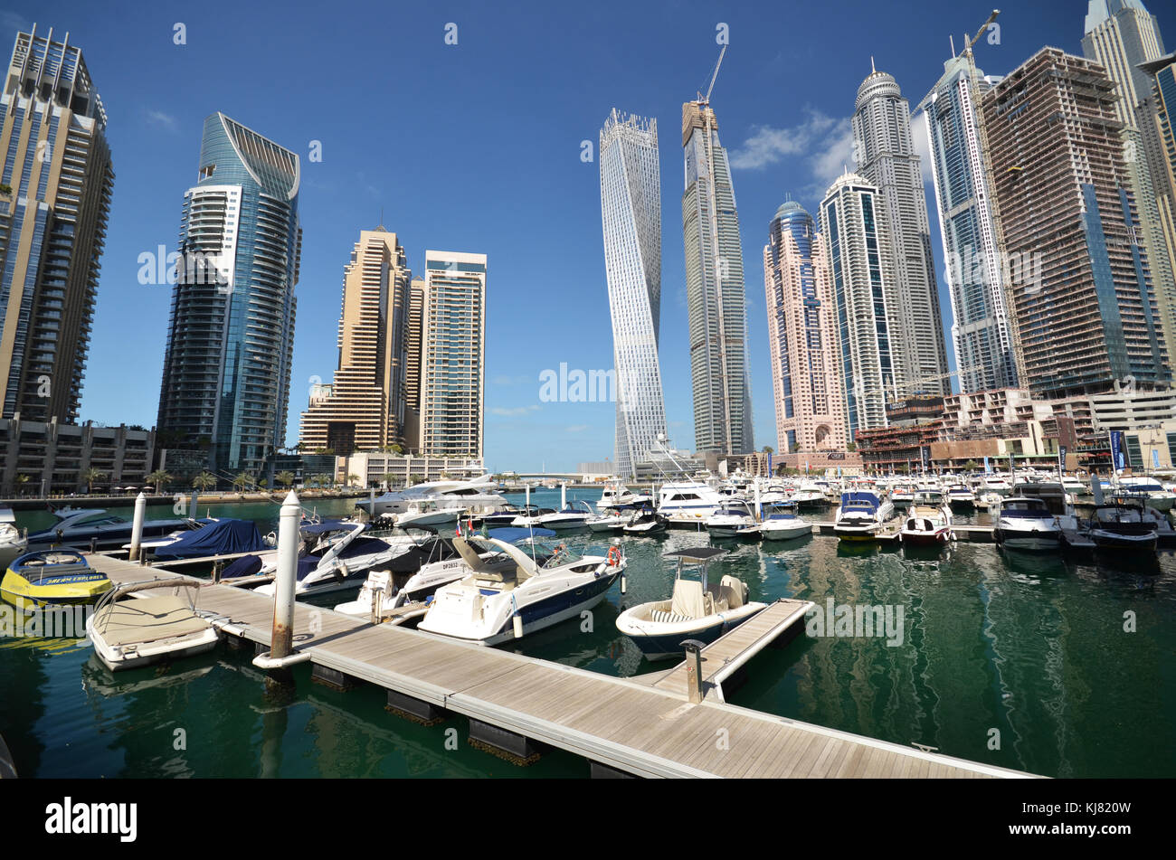 Barche sulla marina di Dubai con alti grattacieli della città in background Foto Stock