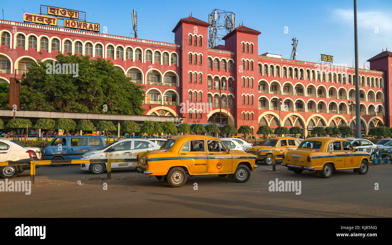 La stazione di Howrah e' un antico edificio architettonico coloniale a Kolkata con vista del traffico cittadino e dei famosi taxi gialli della citta'. Foto Stock