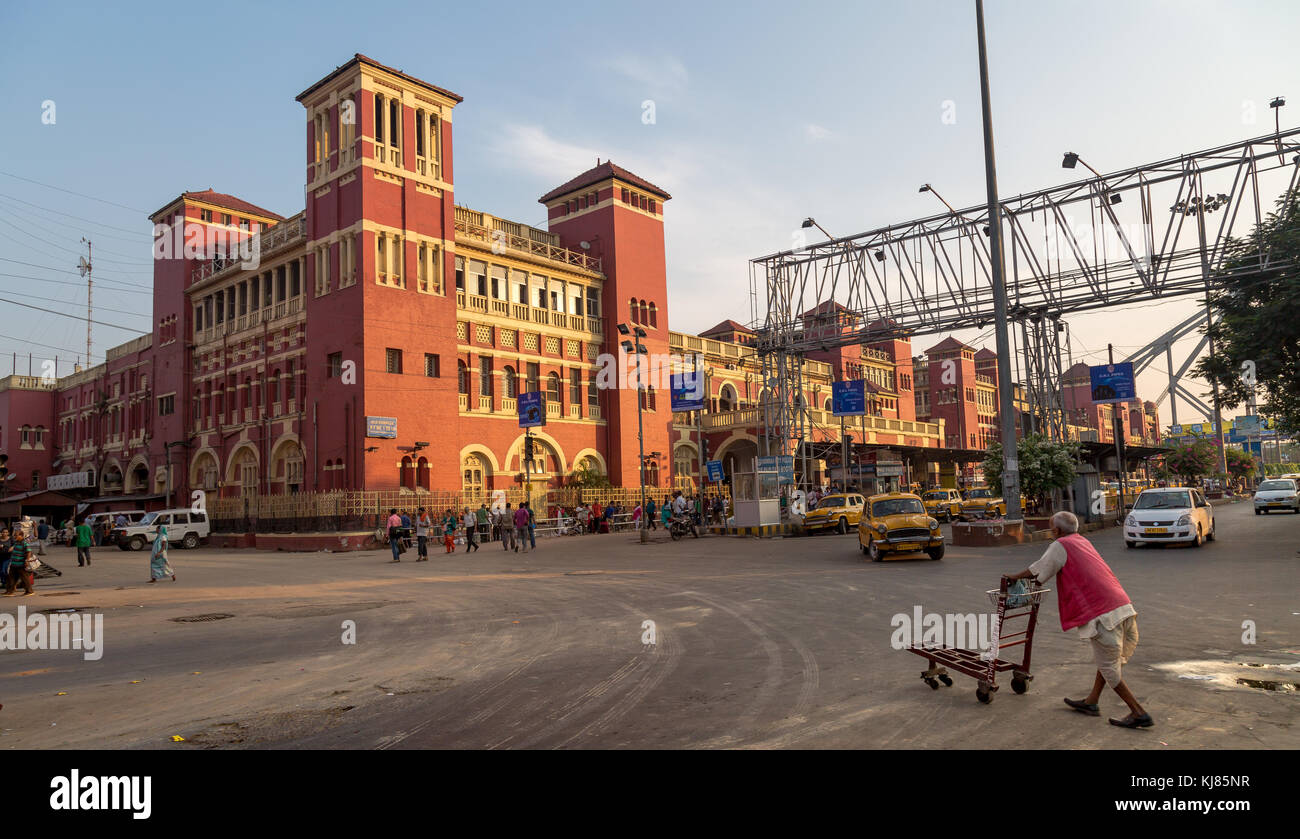 La stazione di Howrah e' un antico edificio architettonico coloniale a Kolkata con vista del traffico cittadino e dei famosi taxi gialli della citta'. Foto Stock