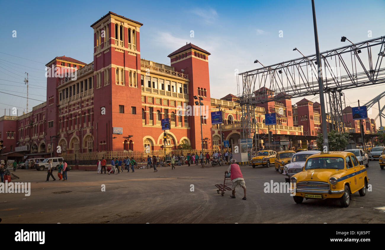 La stazione di Howrah e' un antico edificio architettonico coloniale a Kolkata con vista del traffico cittadino e dei famosi taxi gialli della citta'. Foto Stock