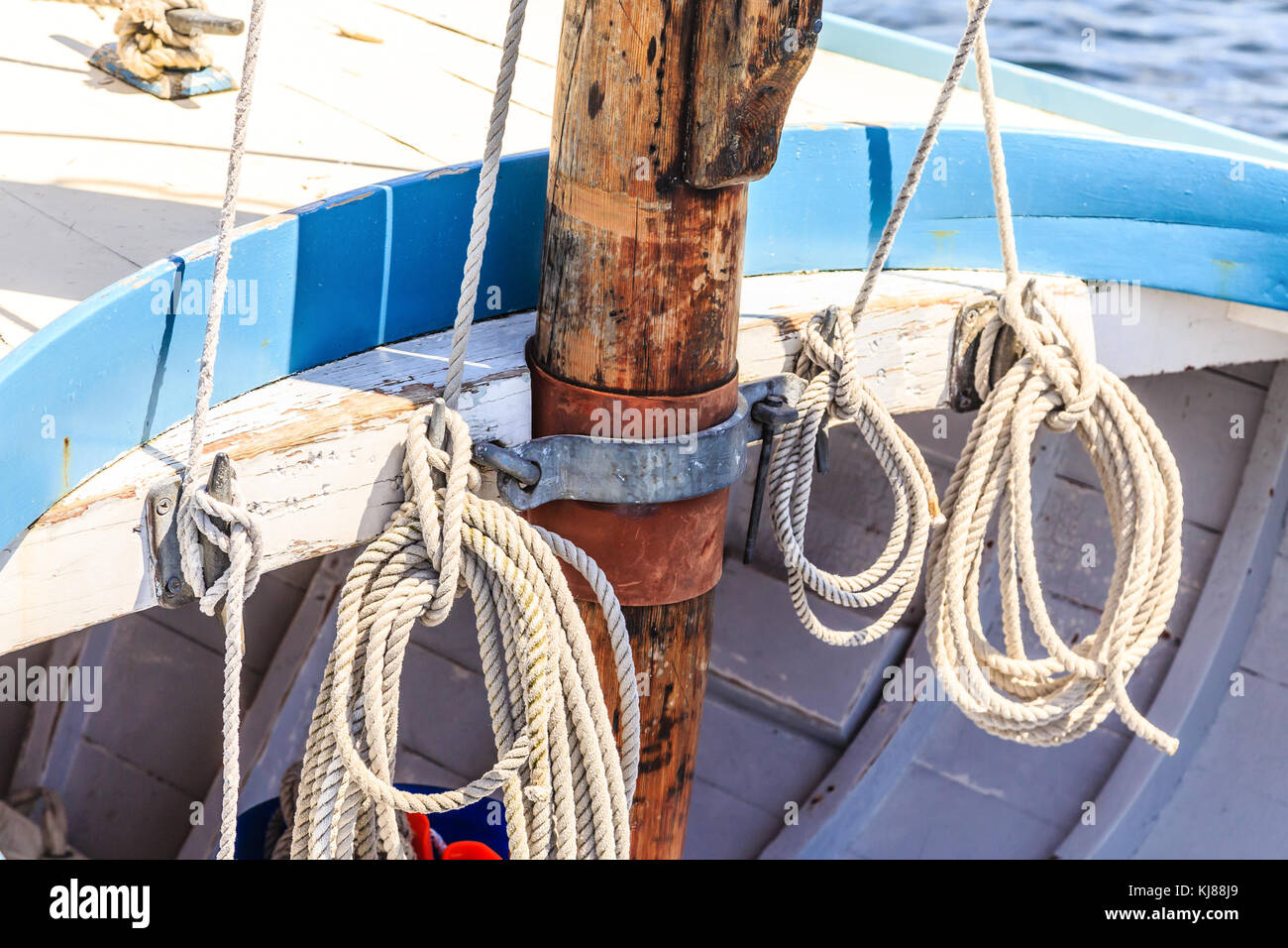 Corda avvolto a spirale dal vecchio montante in legno sulla barca a vela Foto Stock