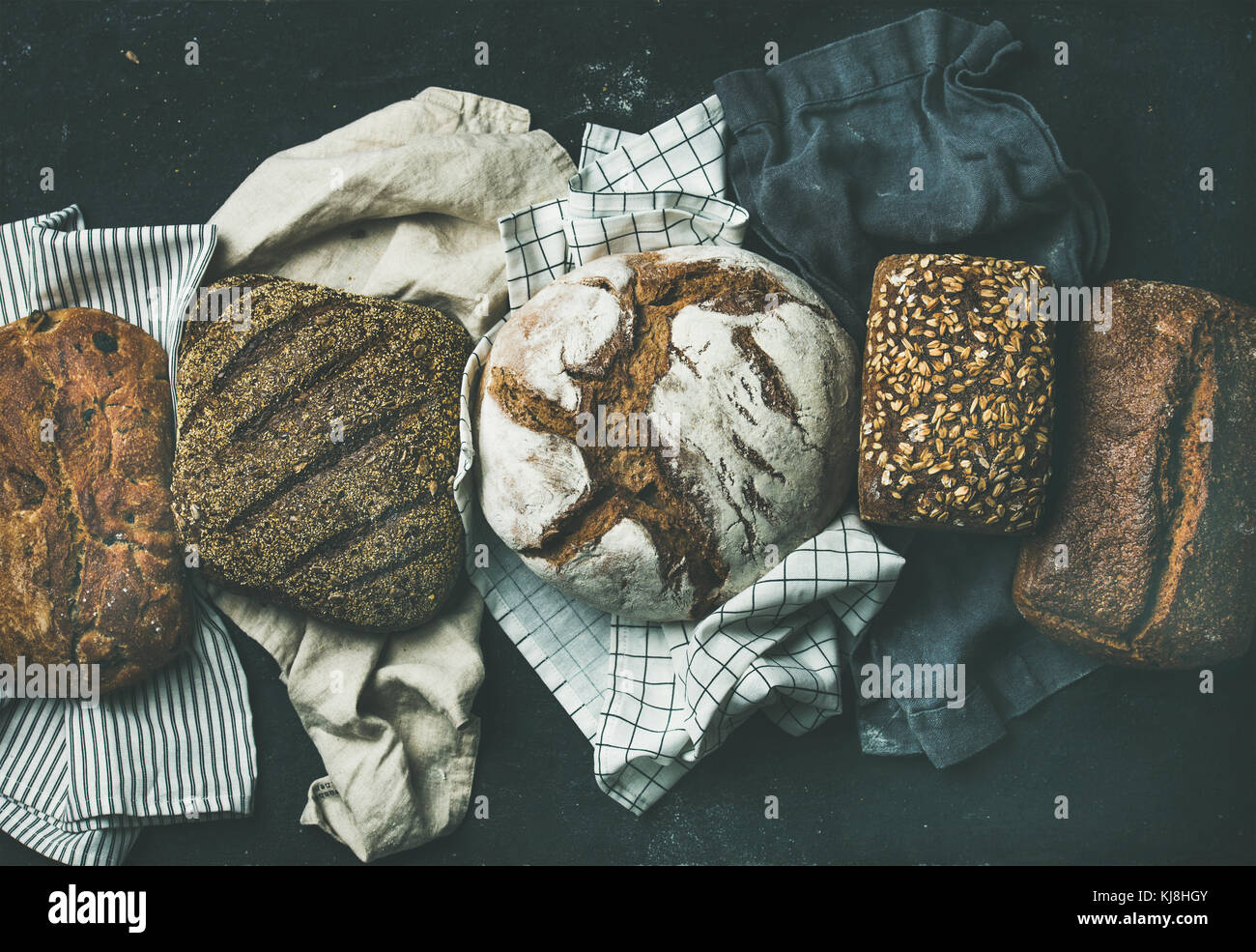 Varie selezione di pane flat-laici, sfondo nero Foto Stock