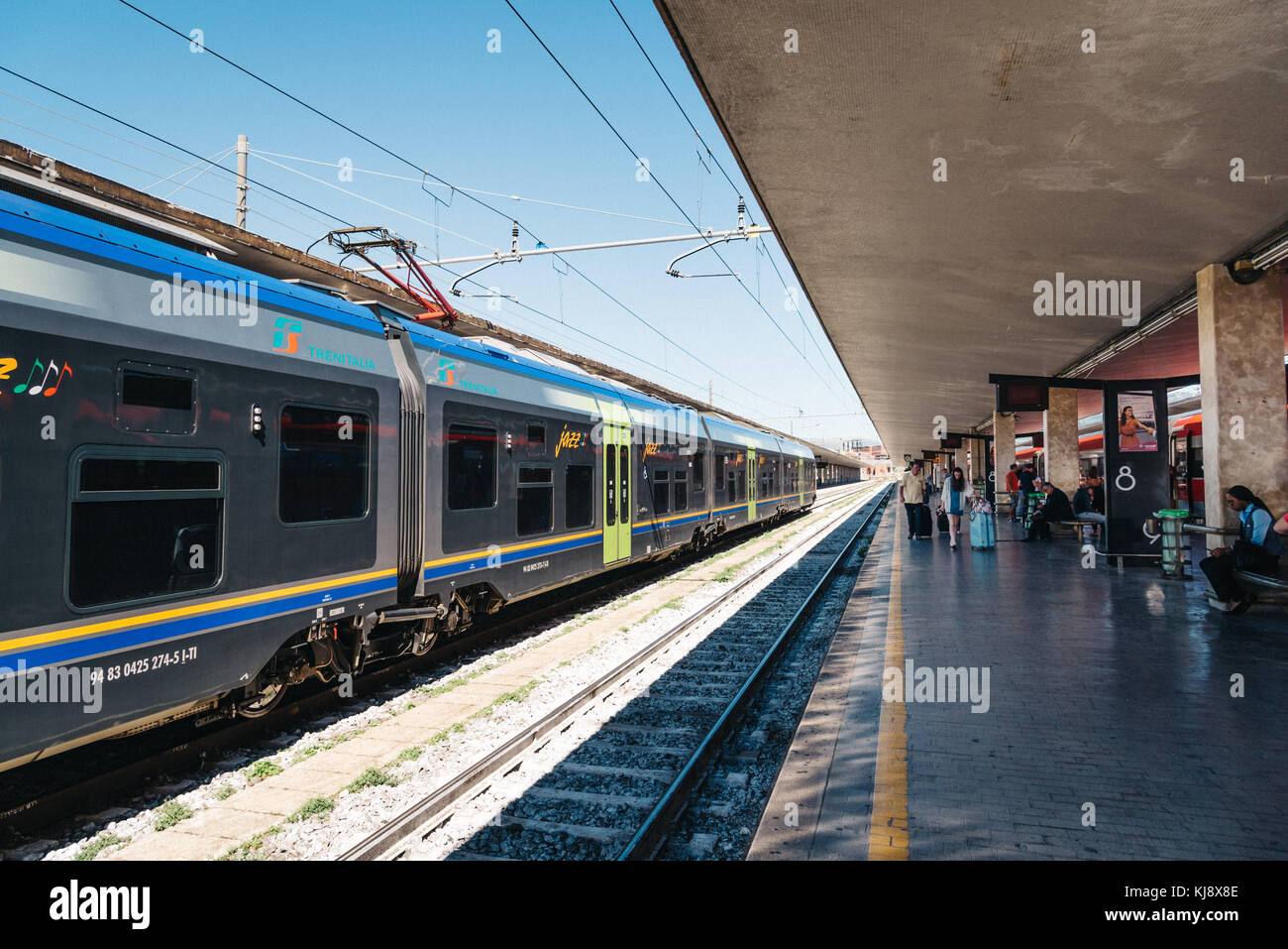 Persone non identificate in attesa del treno in stazione ferroviaria Foto Stock