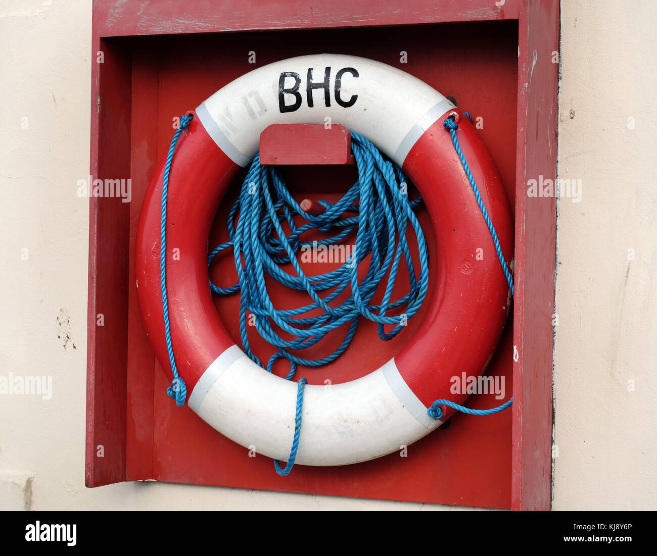 Acqua l'anello di sicurezza nel supporto con la fune fissata sul lato del porto. Foto Stock