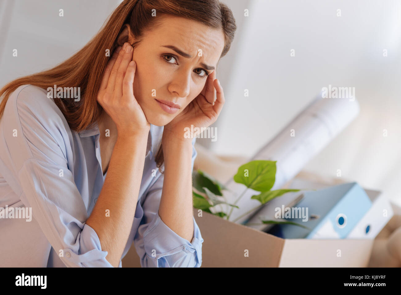 Nervoso sconvolto donna seduta e toccando la sua testa Foto Stock