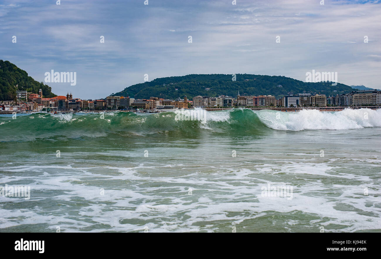 Bella onde turchesi frantumazione su una spiaggia di una piccola cittadina spagnola di san sebastian Foto Stock