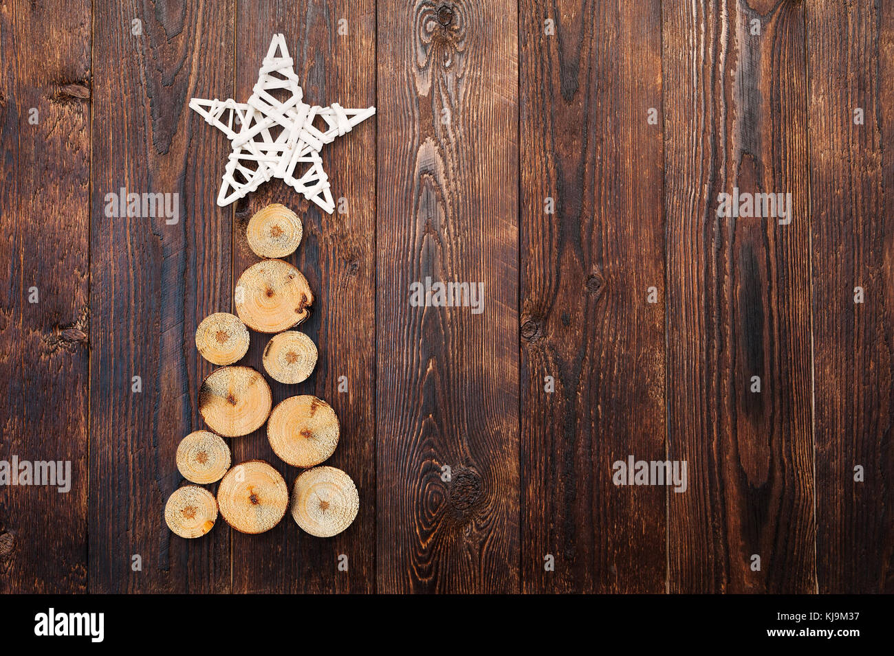 Legno albero di natale e la stella su un legno marrone con lo sfondo di un posto per il vostro testo Foto Stock