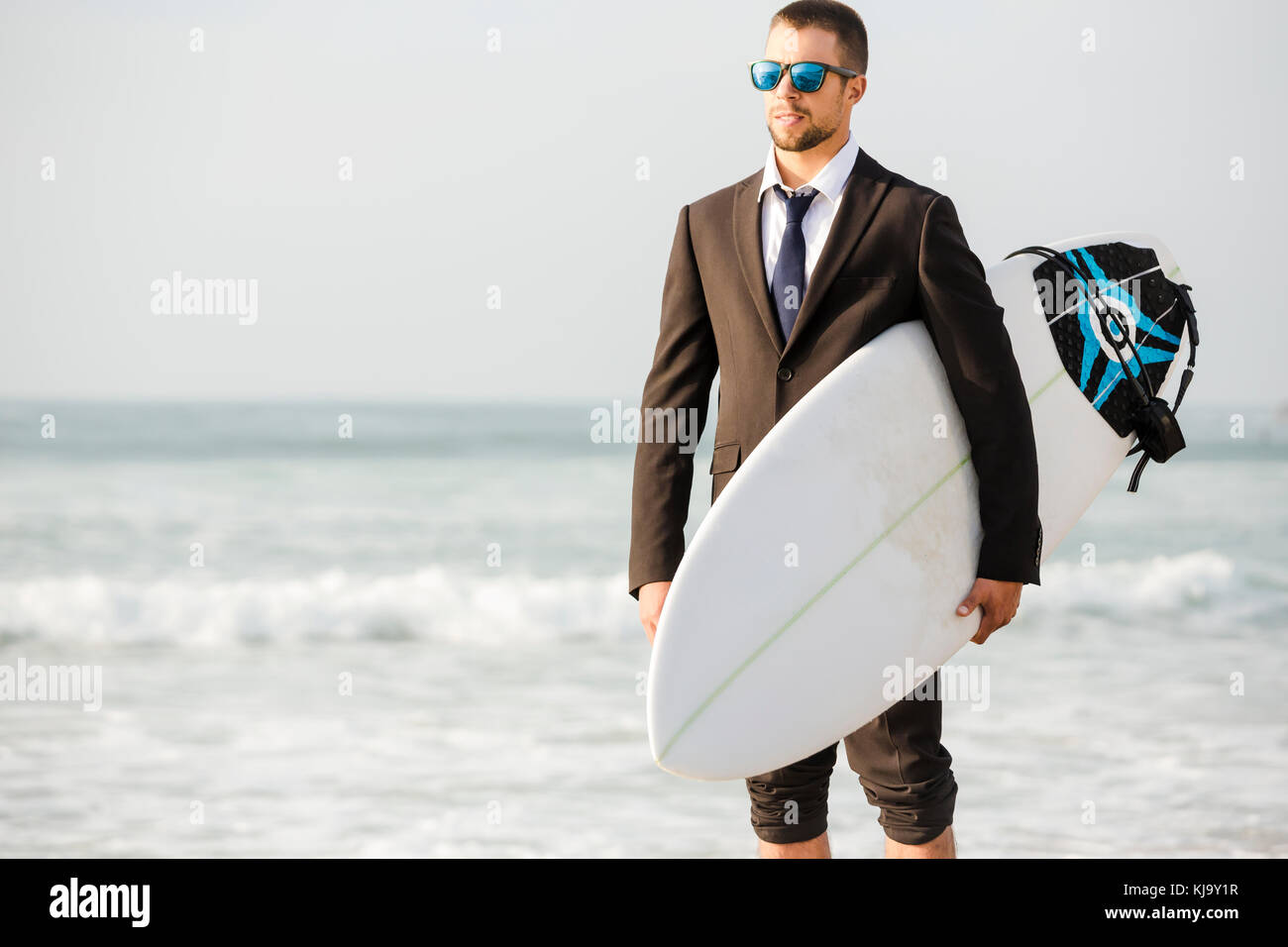 Un imprenditore holding è la tavola da surf dopo una lunga giornata di lavoro Foto Stock