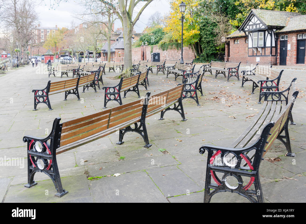 Panchine deserte sui solchi di fronte al palco per spettacoli sulle rive del fiume Dee in Chester in un freddo giorno di autunno Foto Stock