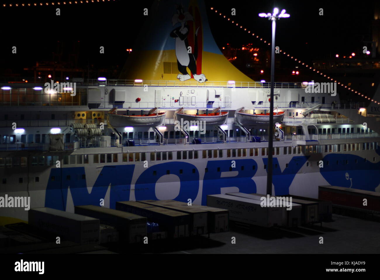 Un gigantesco traghetto moby Lines nel porto di Genova, in Italia, di notte, pronto a salpare verso l'acqua di mare aperto. Foto Stock