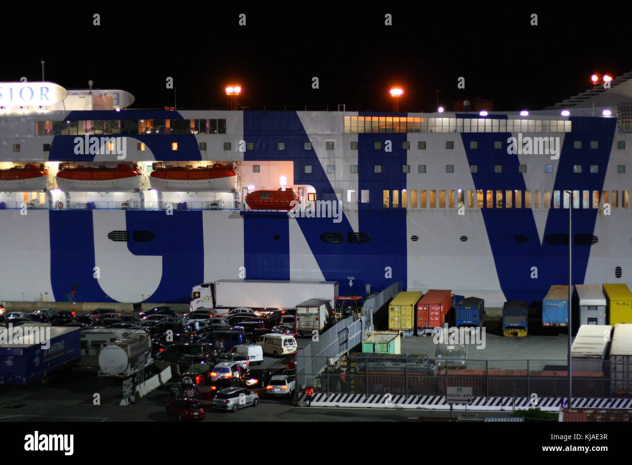 Un gigantesco traghetto GNV Lines nel porto di Genova, in Italia, di notte, pronto a salpare verso l'acqua di mare aperto. Foto Stock