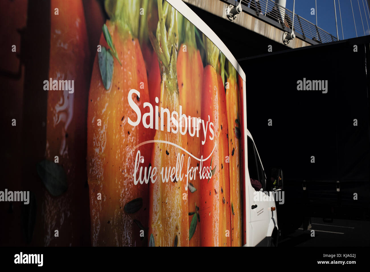 Close up Sainsbury's consegna van guida su strade di Londra Inghilterra concentrandosi sulla segnaletica. Foto Stock