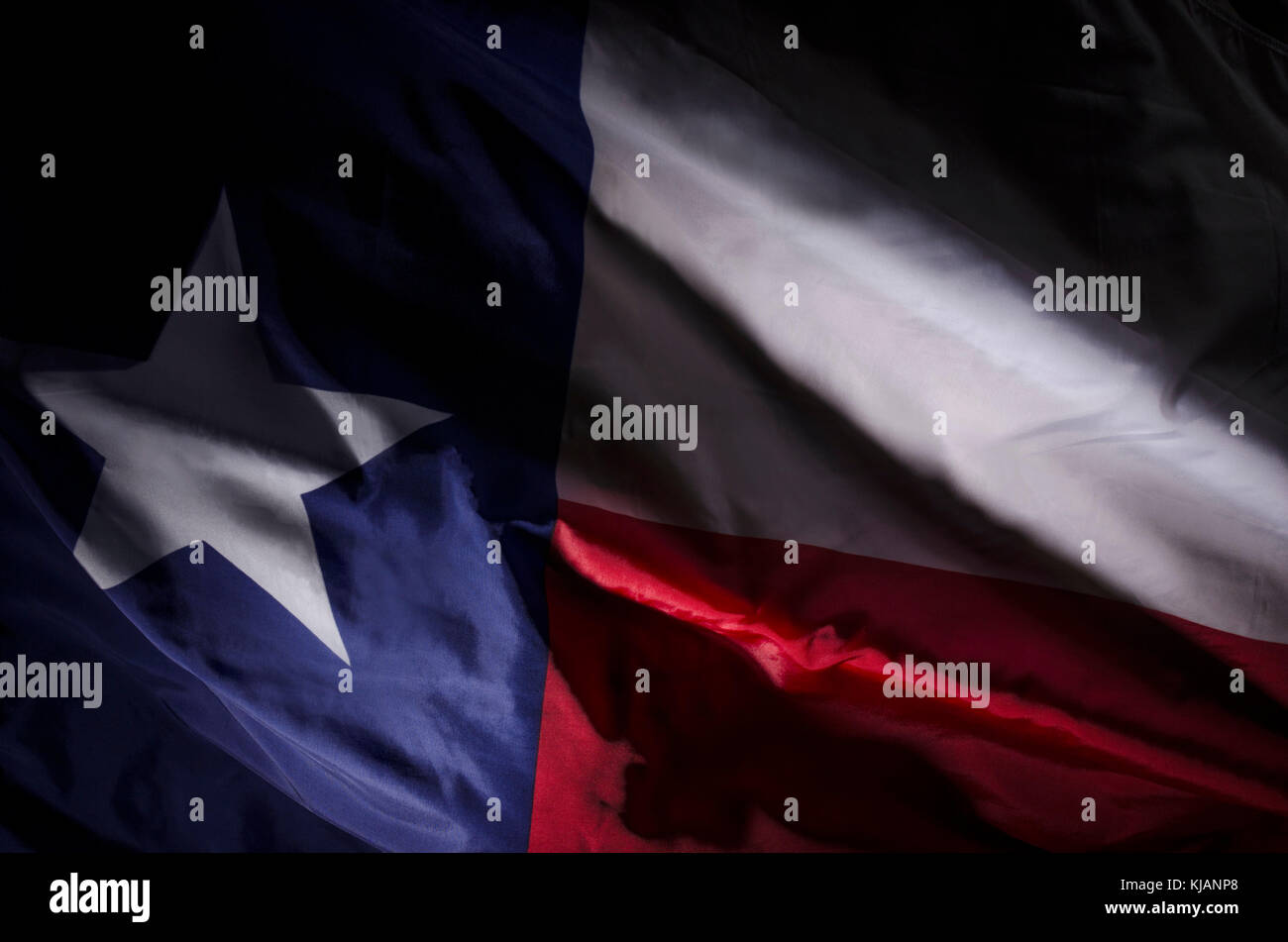 Primo piano della bandiera Texas Lone Star con luci e ombre spettacolari che enfatizzano le onde, i dettagli dei tessuti e il contrasto dei colori. Foto Stock