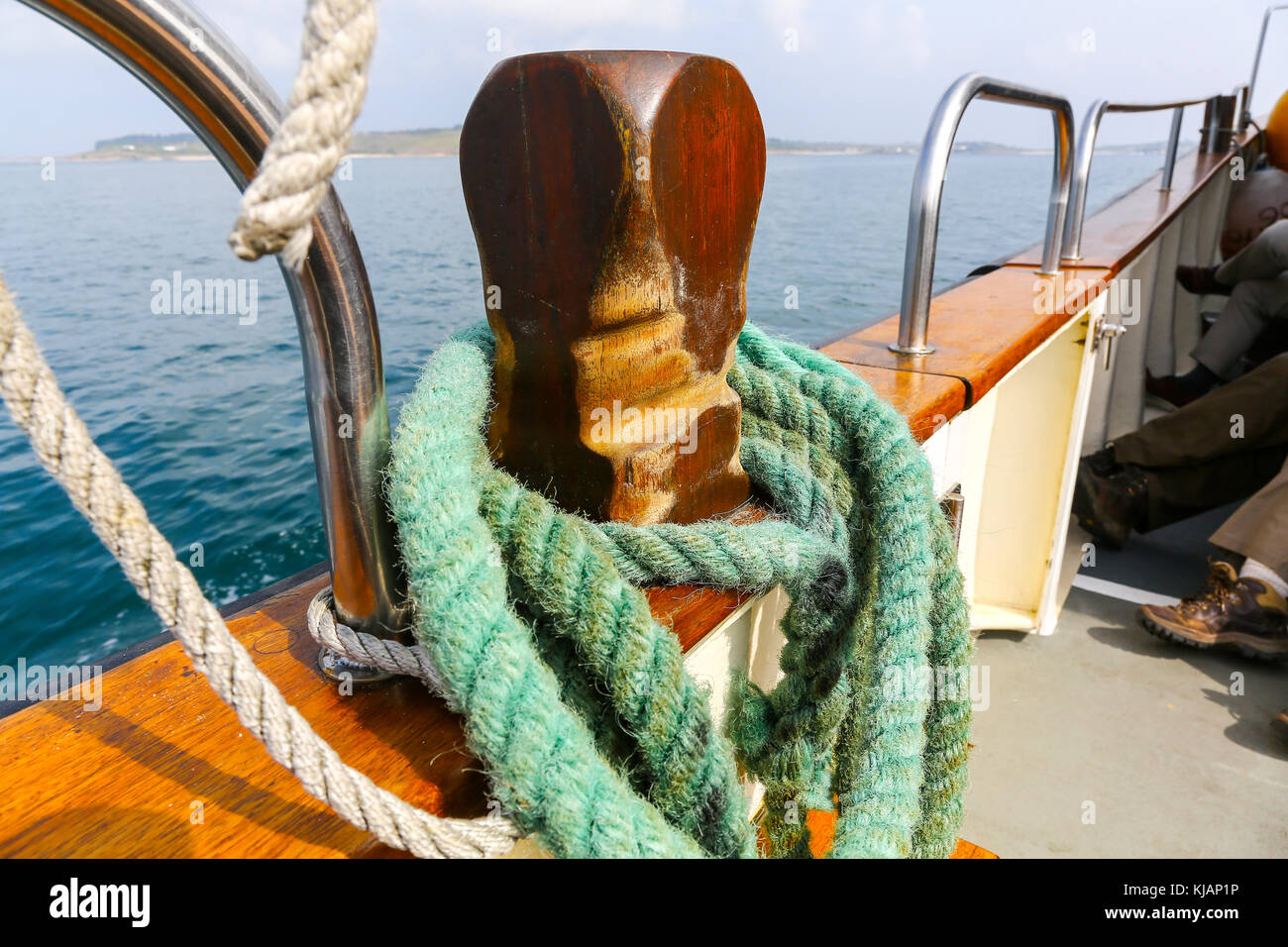 Una corda legata intorno ad un rullo di trazione sul lato di una barca in mare Foto Stock