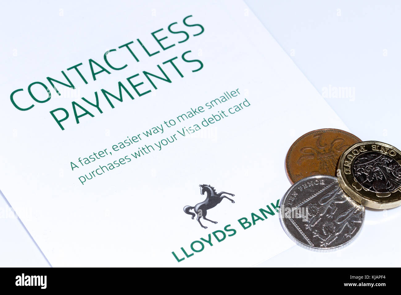 Opuscolo sui pagamenti contactless per la banca Lloyds e alcuni piccoli cambiamenti, monete inglesi in sterline, Regno Unito Foto Stock