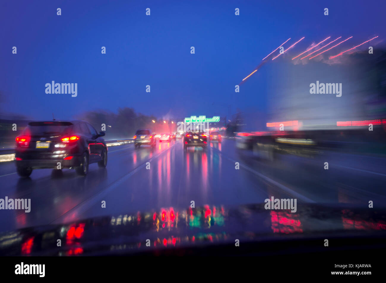 Vetture su strada nella pioggia notturna sfocata Foto Stock