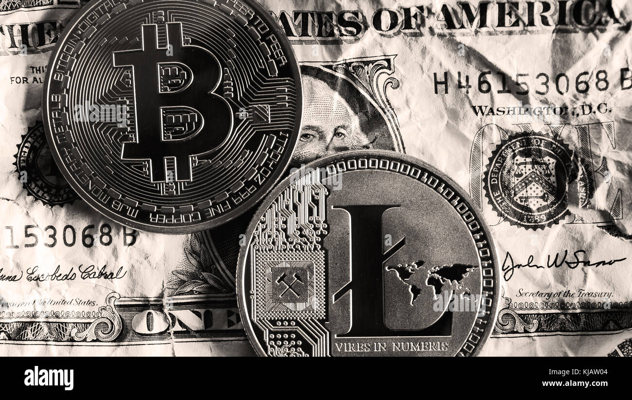 Bitcoin e litecoin su dollar banconote sui toni del bianco e del nero. cryptocurrency concetto di trading . Foto Stock