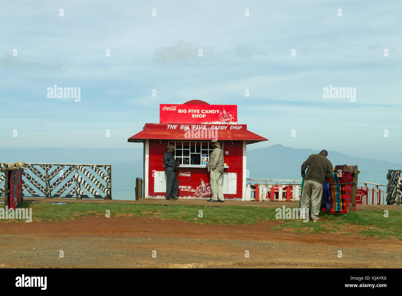 Un piccolo negozio di curiosita' fatta da lamiere grecate con persone in piedi fuori, Kenya, Africa orientale Foto Stock