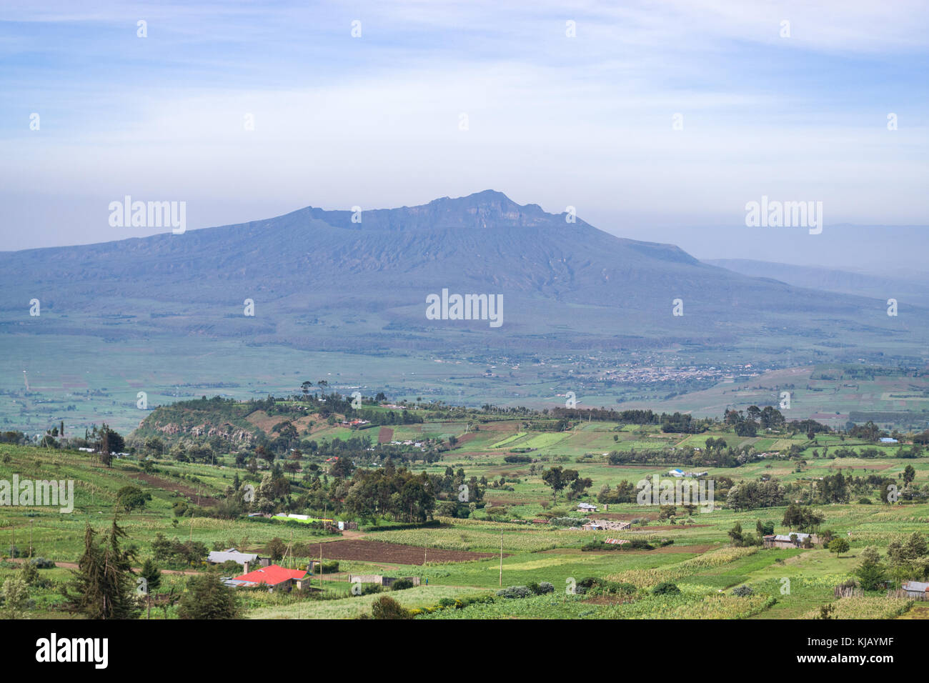 Supporto Longonot nella lontana haze durante la stagione delle piogge con terreni coltivati e la campagna sottostante, Kenya, Africa orientale Foto Stock