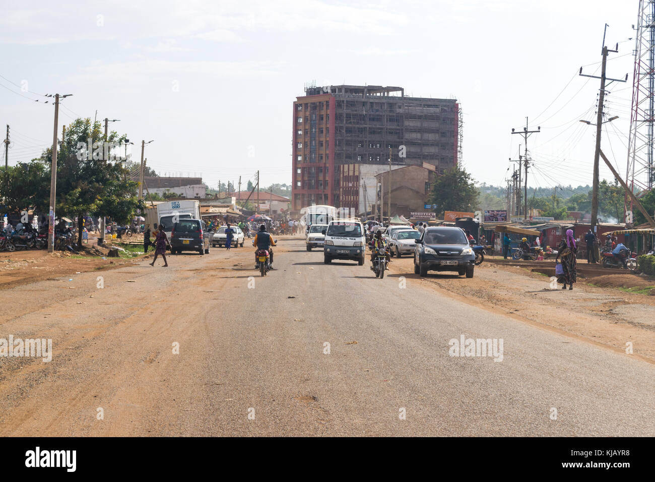 La strada principale che corre attraverso Bondo città nel Kenya occidentale con le persone e di traffico su di essa, Africa orientale Foto Stock