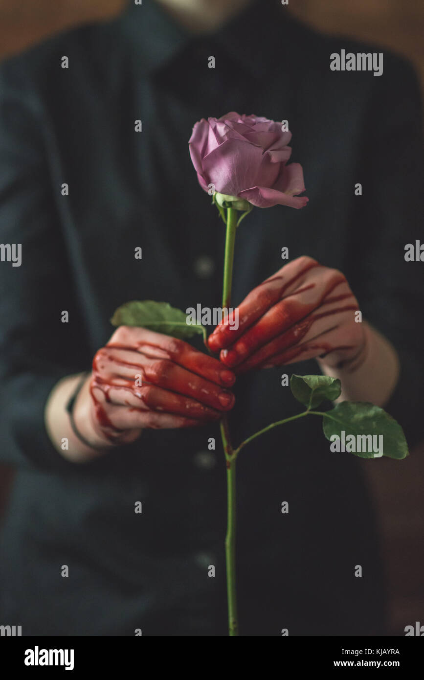 Giovani donne in possesso di una sanguinosa Rose Foto Stock