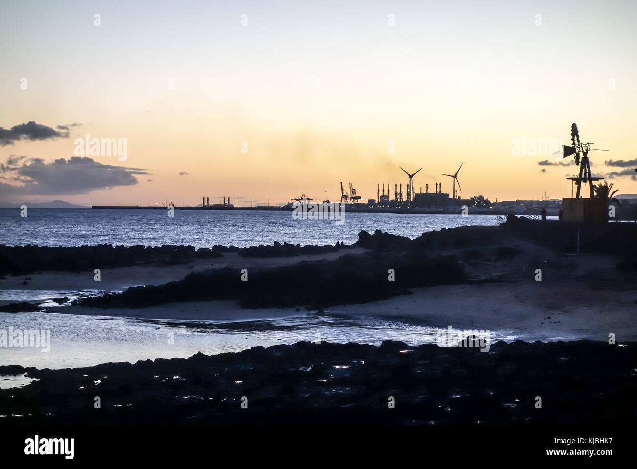 LANZAROTE, SPAGNA-4 novembre 2017: Tramonto nella principale località turistica della Costa Teguise con la centrale elettrica dell'isola per l'approvvigionamento energetico sul retro Foto Stock