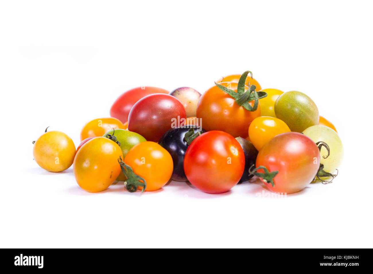 Cluster di piccoli pomodori ciliegia in una varietà di colori isolati su sfondo bianco Foto Stock