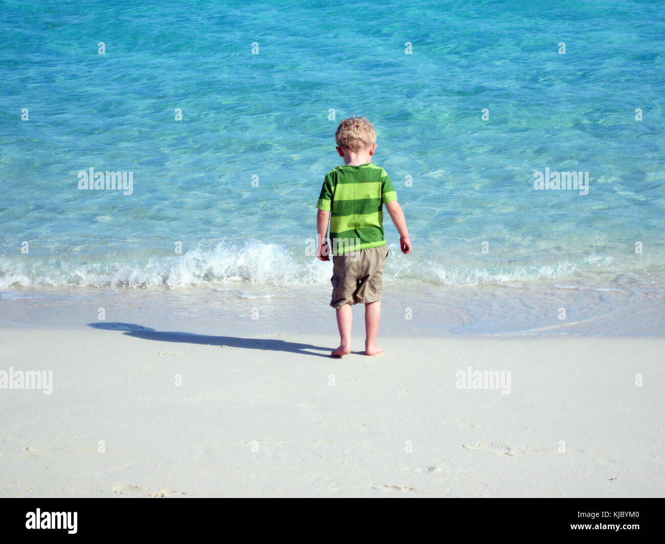 Giovane ragazzo in piedi di fronte all'oceano Foto Stock