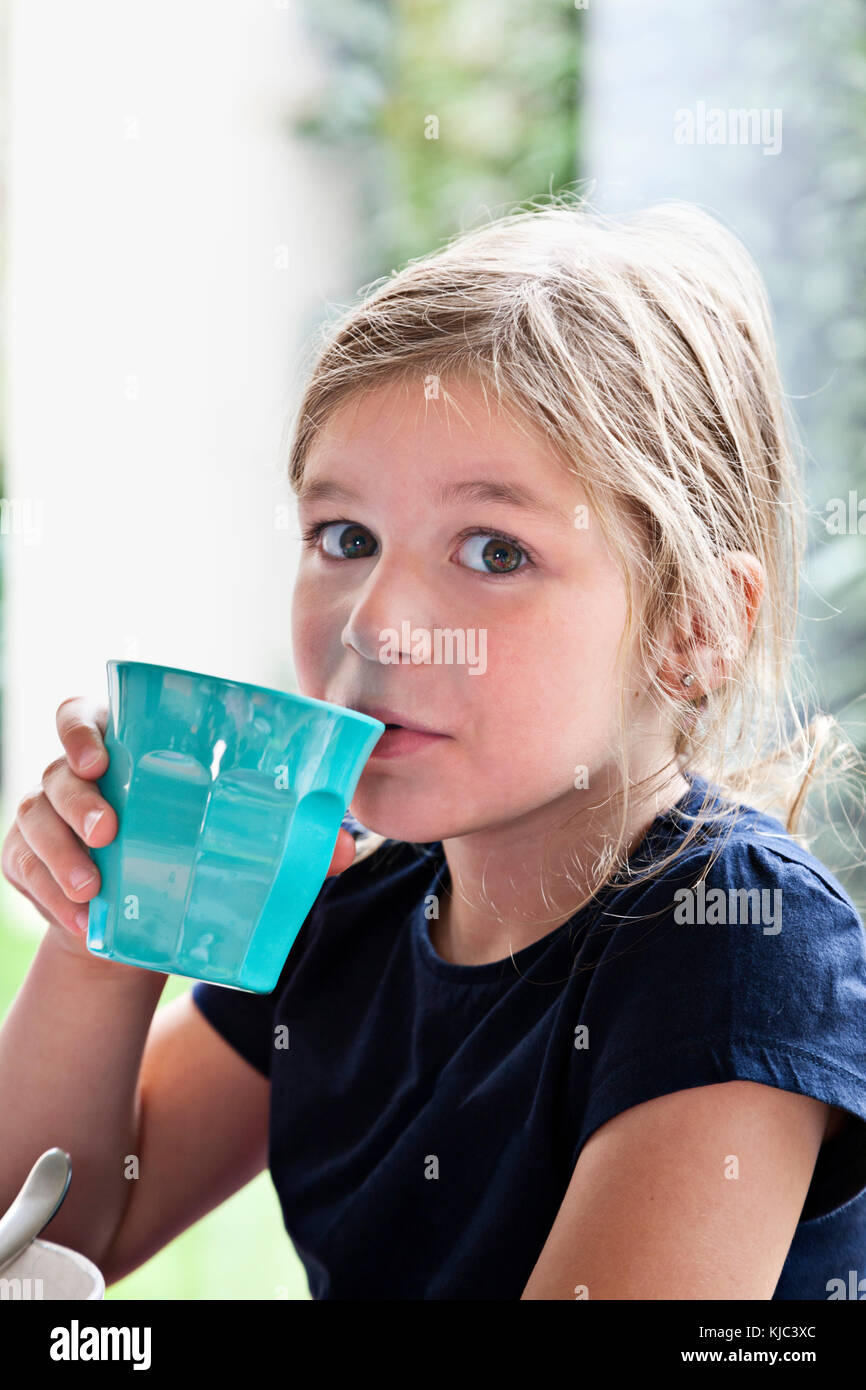 Ragazza che beve dalla Blue Cup Foto Stock