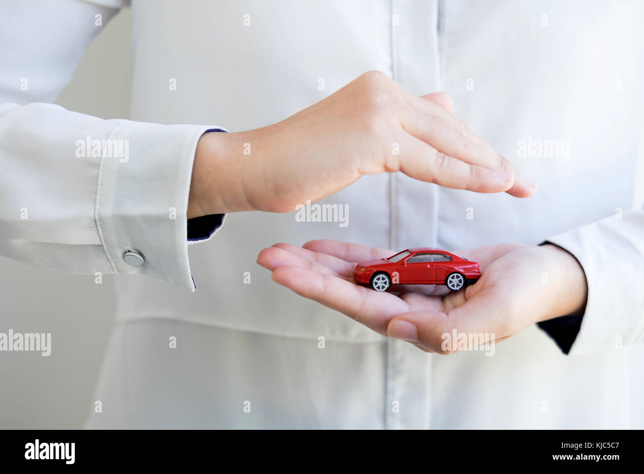Auto (automobile) assicurazione e la rinuncia a danni da collisione concetti. Imprenditrice con gesto protettivo e auto. soluzione per la migliore protezione Foto Stock