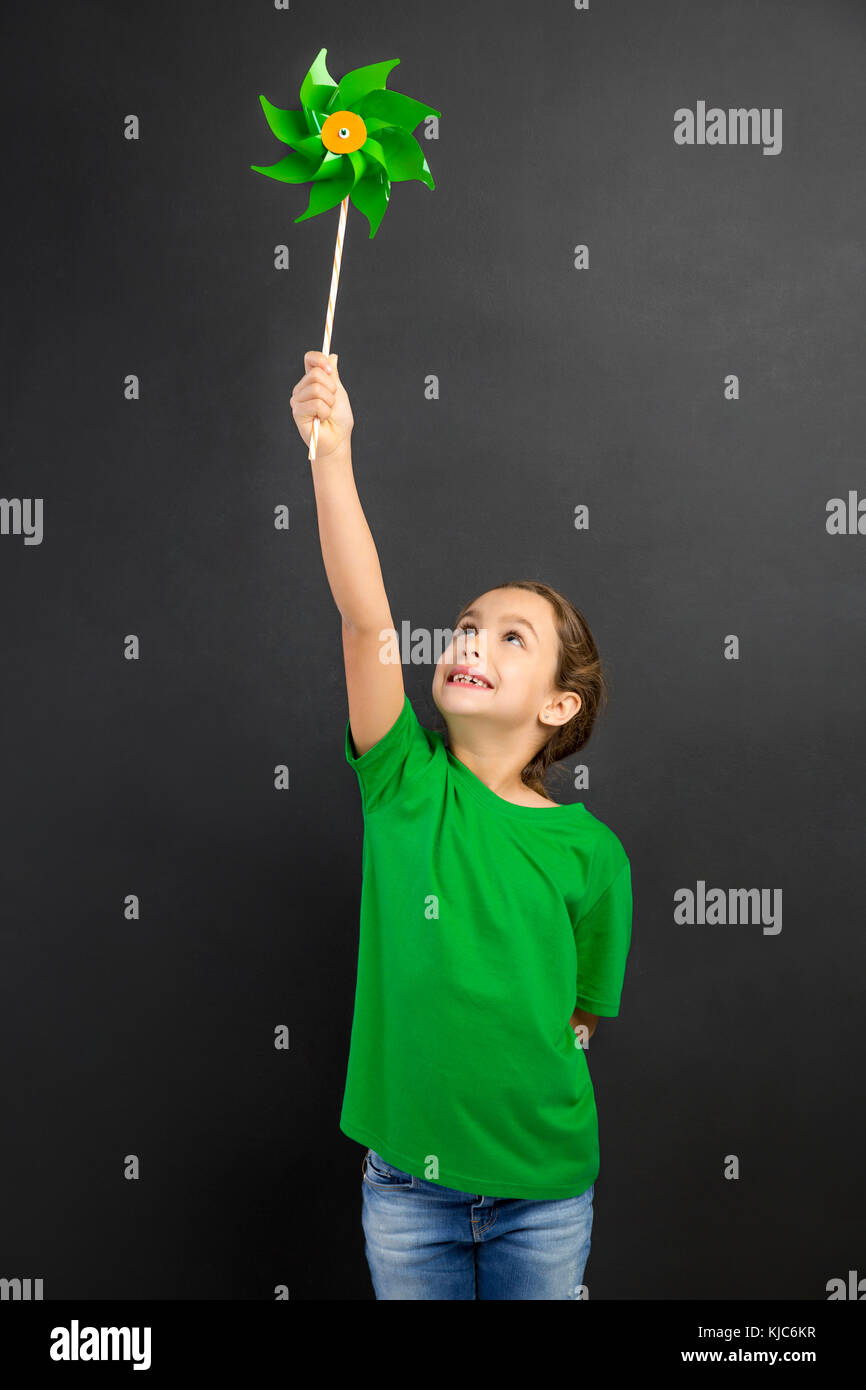 Bellissima bambina smilling e trattenimento di un mulino a vento Foto Stock