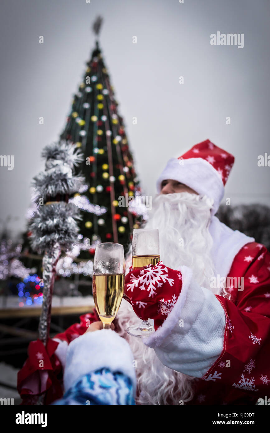 Celebrazione e anno nuovo concetto. l uomo con la barba detiene il vetro di champagne. guy vicino albero di natale nel parco santa claus in Red Hat. Felice anno nuovo! Foto Stock