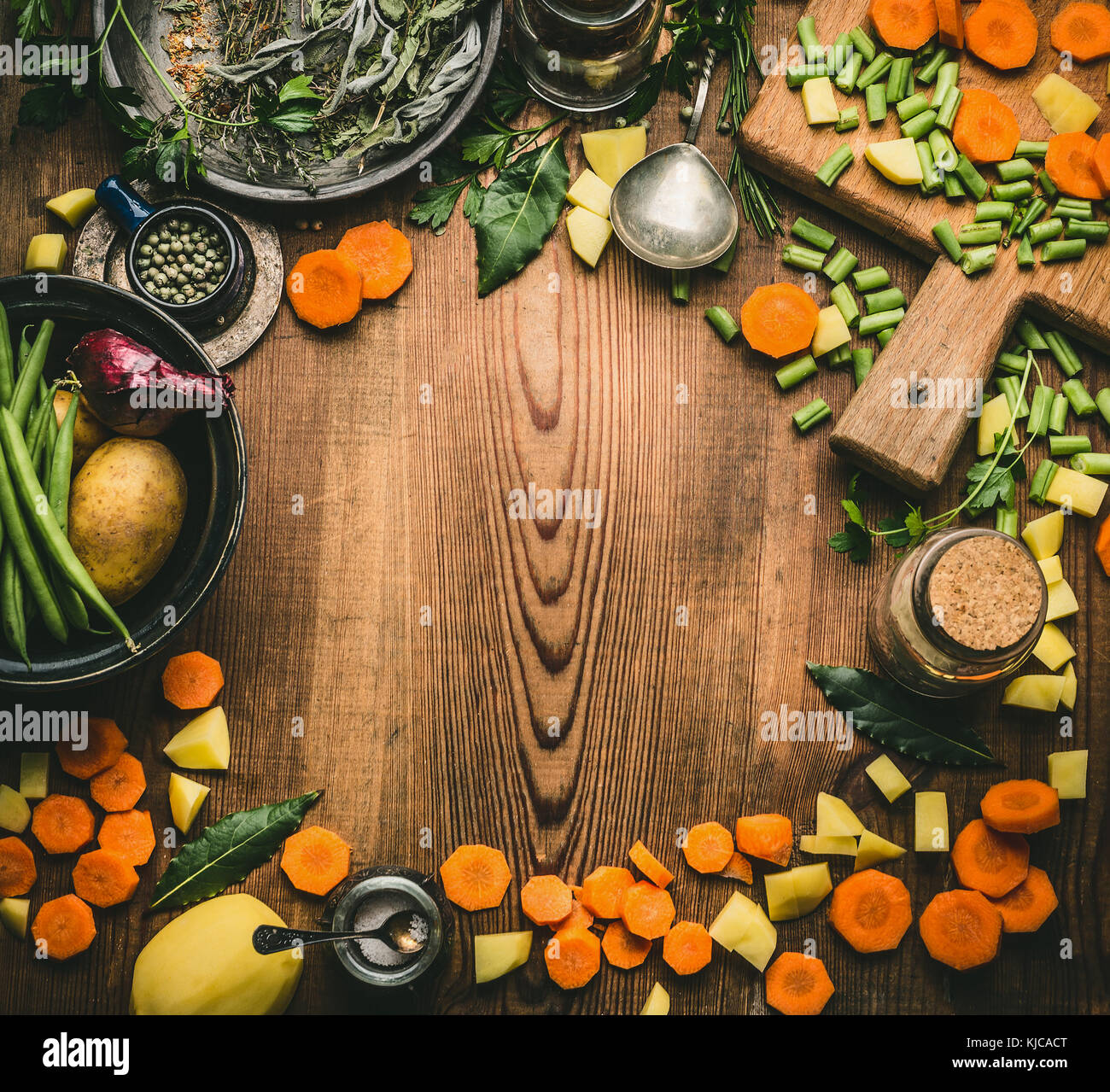 Pulire sano cucinare e mangiare concetto. tavolo da cucina da sopra con vari ingredienti: un trito di verdure, erbe e spezie, tagliere e s Foto Stock