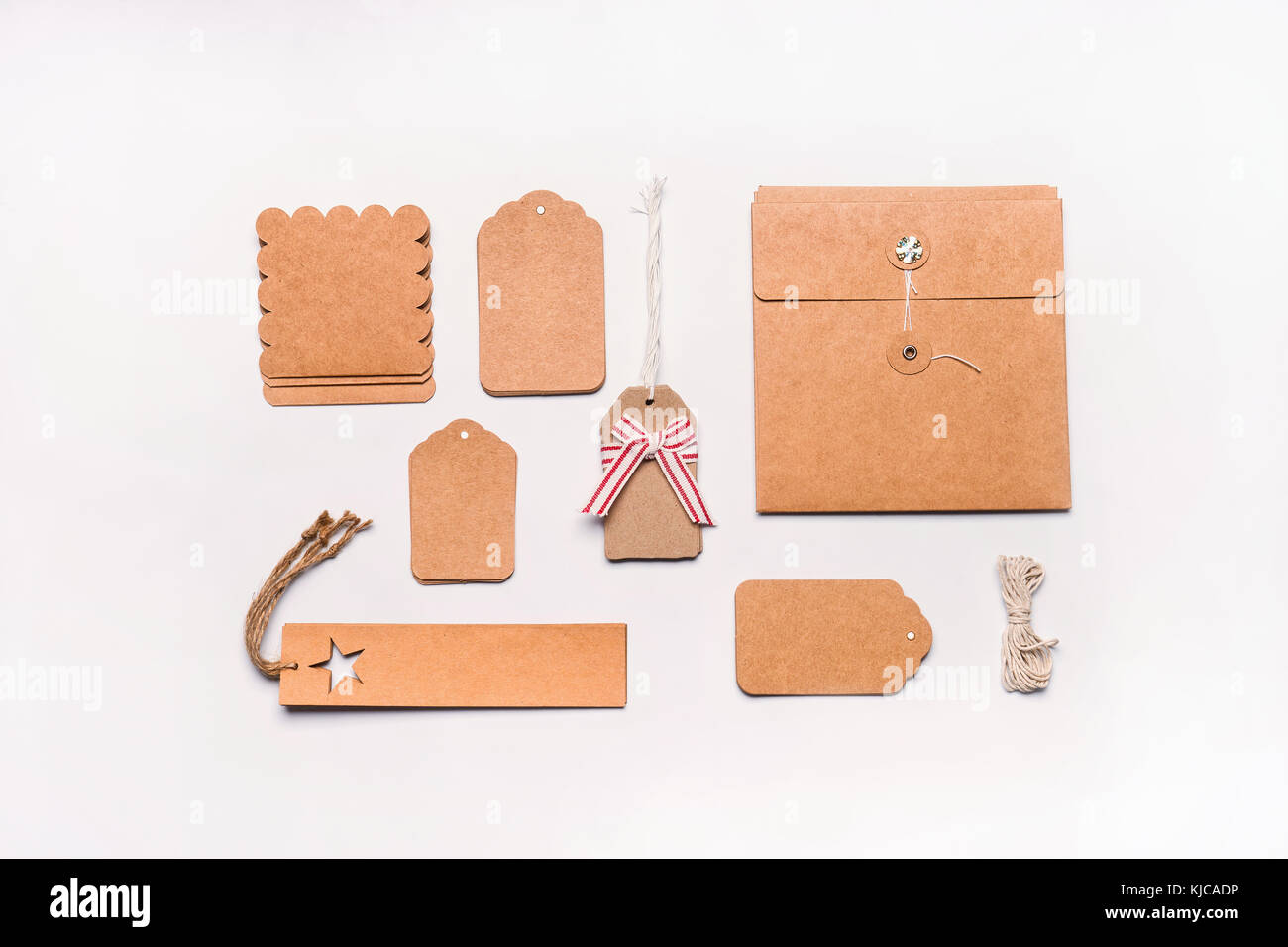 Doni concetto di incarto. laici piana di vario artigianato carta eco confezione di cartone e tag su bianco lo sfondo del desktop, vista dall'alto. Foto Stock