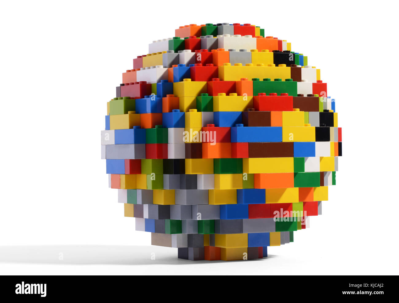 Close-up studio shot di un colorato sfera in plastica fatta di toy mattoni di edificio con ombra su sfondo bianco per lo spazio di copia Foto Stock