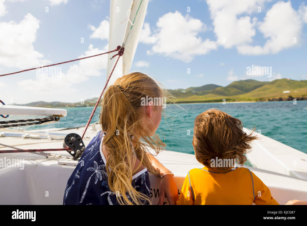 Vento capelli caucasici di fratello e sorella in barca a vela Foto Stock