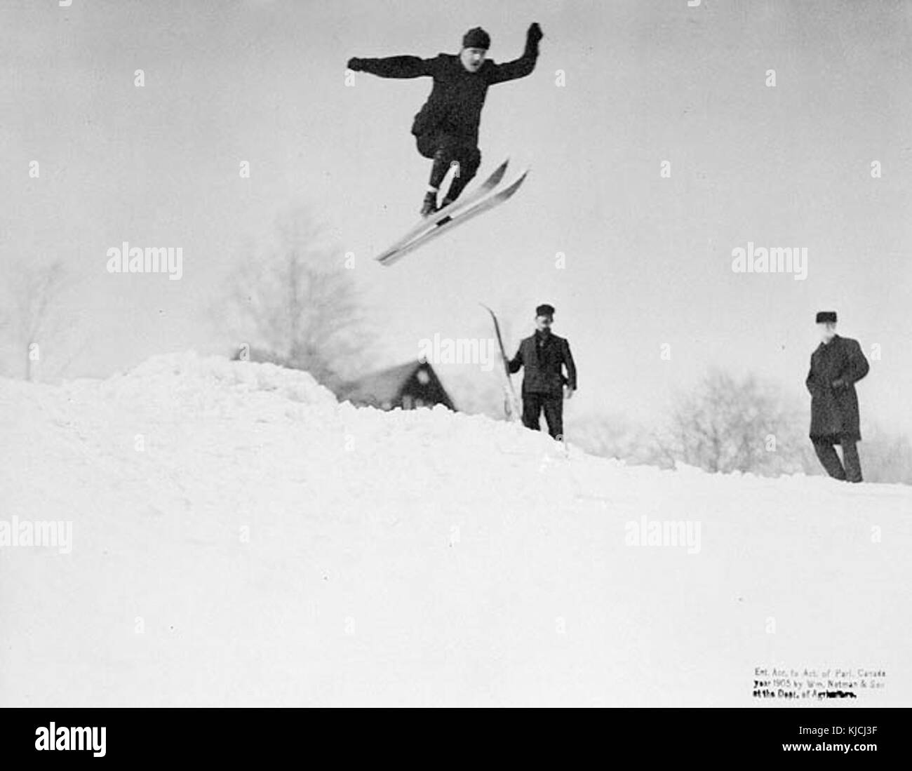 Questa immagine mostra una gara di salto con gli sci dei primi anni del XX secolo, evidenziando l'abilità e la precisione necessarie per questo sport. Il salto con gli sci si è evoluto nel tempo, diventando uno sport invernale di primo piano nei Giochi olimpici. Foto Stock