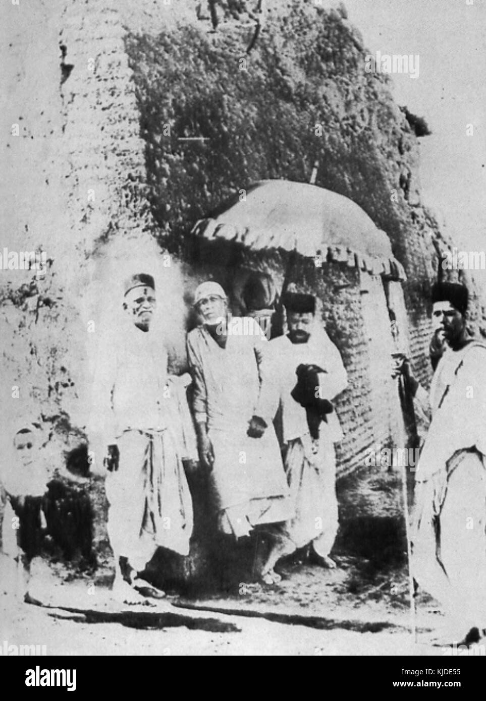 Questa immagine mostra Sai Baba che regge un ombrello, un simbolo comune delle sue benedizioni protettive. Sai Baba di Shirdi era un venerato leader spirituale in India, noto per i suoi insegnamenti di amore, devozione e servizio all'umanità. Foto Stock