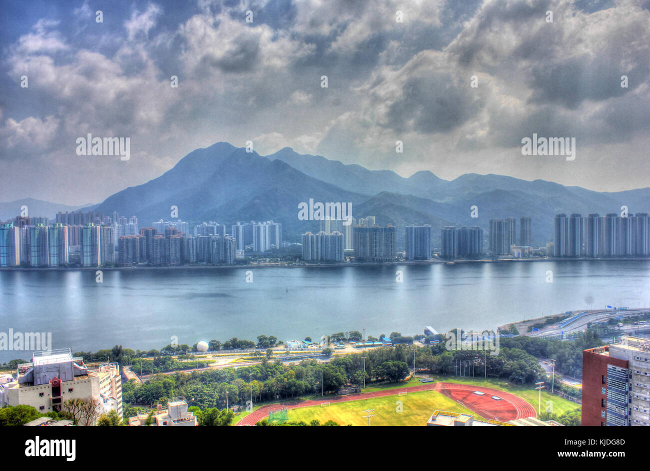 Un'immagine del paesaggio urbano di Hong Kong con lo sfondo di montagne, che mette in risalto il contrasto tra paesaggi urbani e naturali. Foto Stock