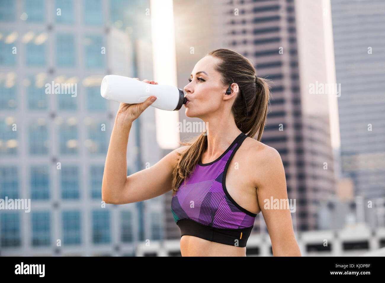 La donna caucasica acqua potabile in città Foto Stock
