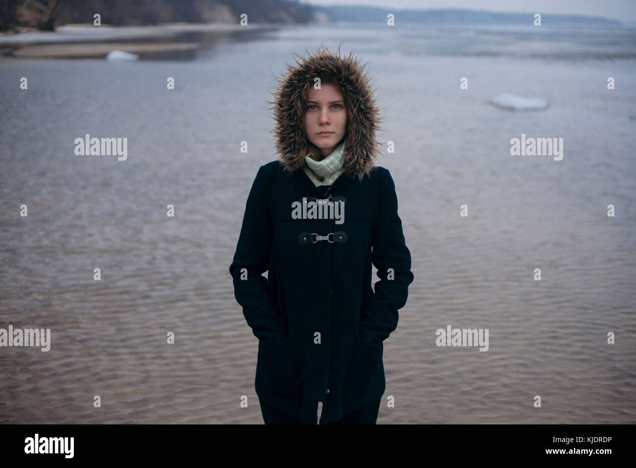 La donna caucasica indossando cappotto vicino a Ocean Foto Stock