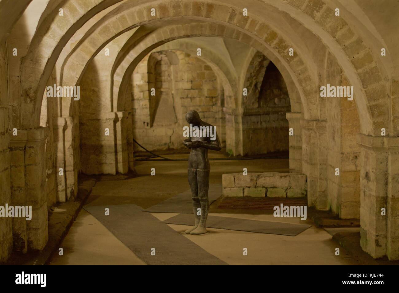 Anthony Gormley della scultura del suono ii nella cripta della cattedrale di Winchester. La scultura mostra un uomo ascoltando il suono della sua anima, Regno Unito Foto Stock