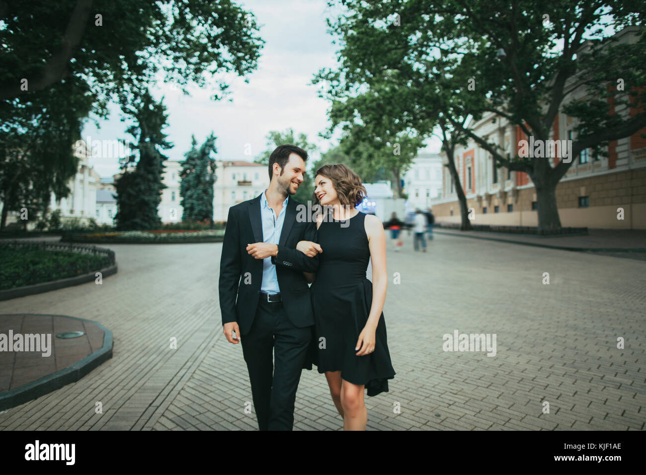 Sorridente coppia caucasica camminando a braccetto Foto Stock